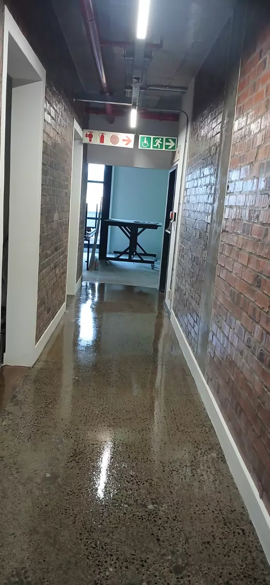 Industrial hallway with exposed brick walls and polished concrete floor