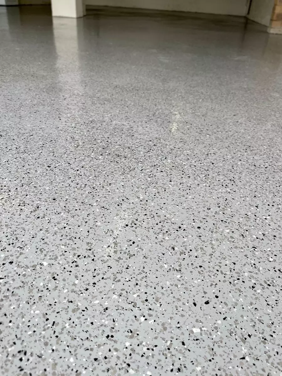 Glossy speckled grey epoxy flake floor in a garage