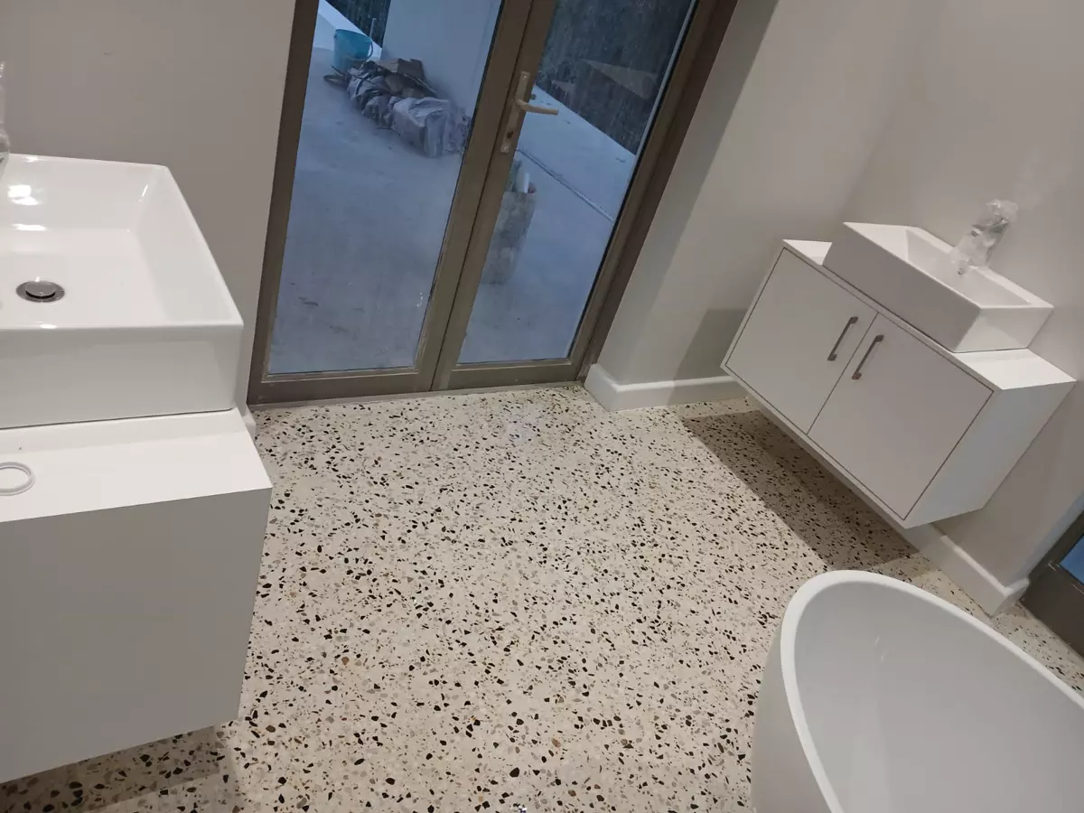 Modern bathroom with terrazzo flooring and freestanding bathtub